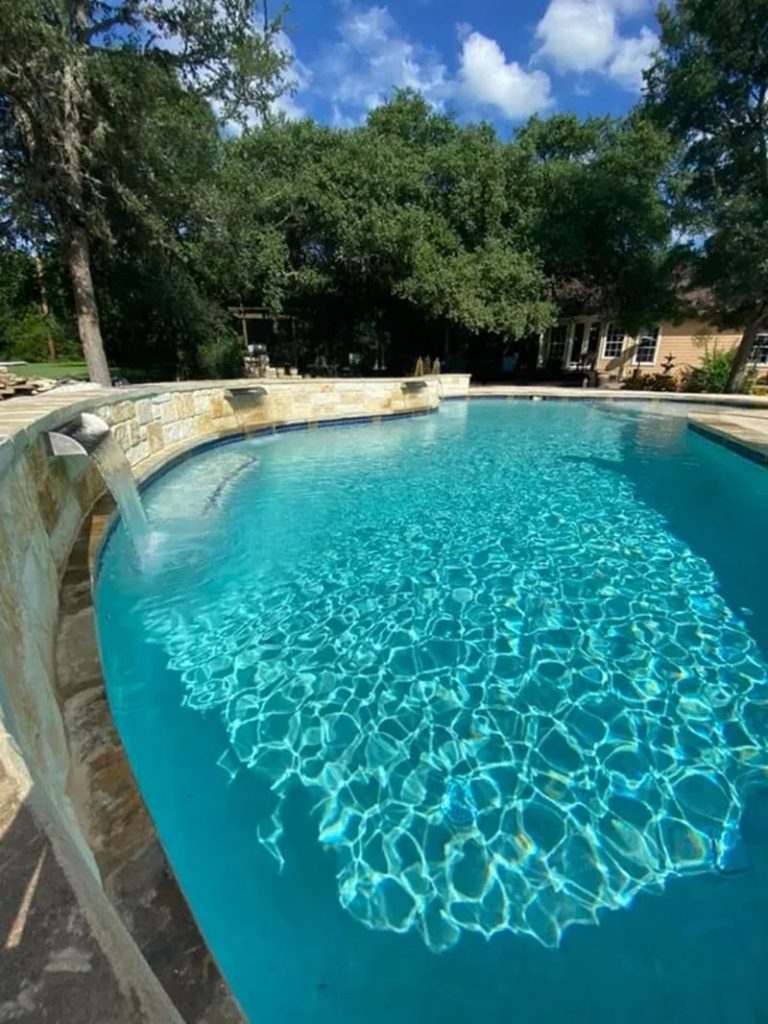 stone-surrounded pool with visible waterfall pouring water into the pool